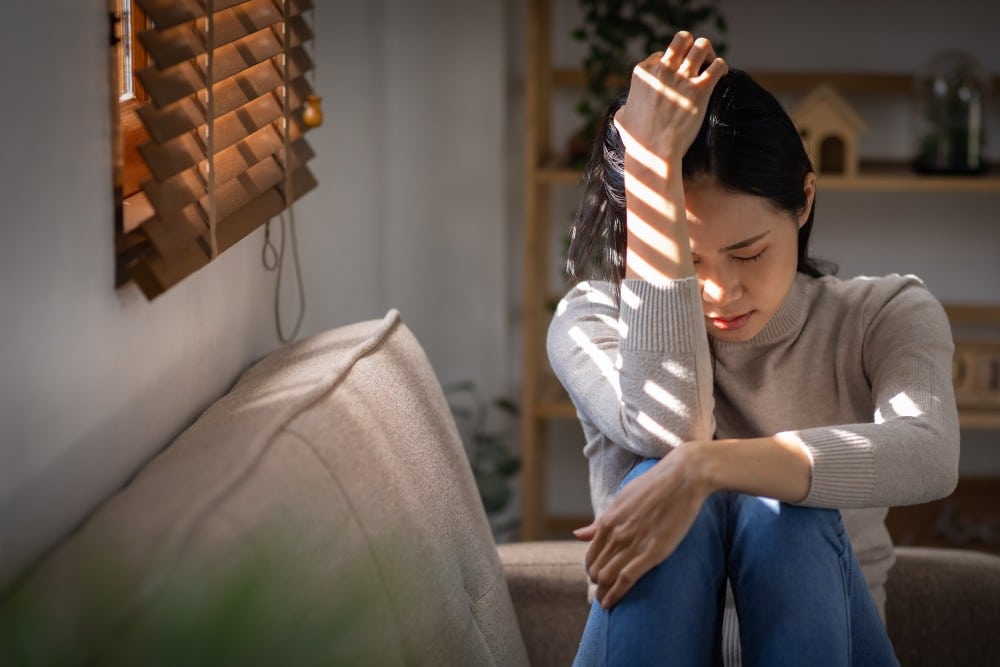sad woman sitting on a sofa in the living room