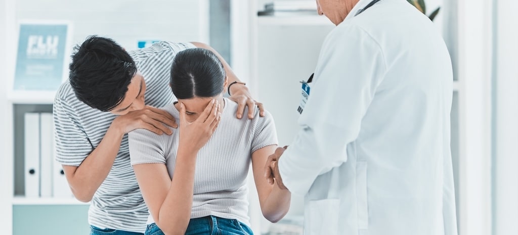 Upset woman talking with doctor.