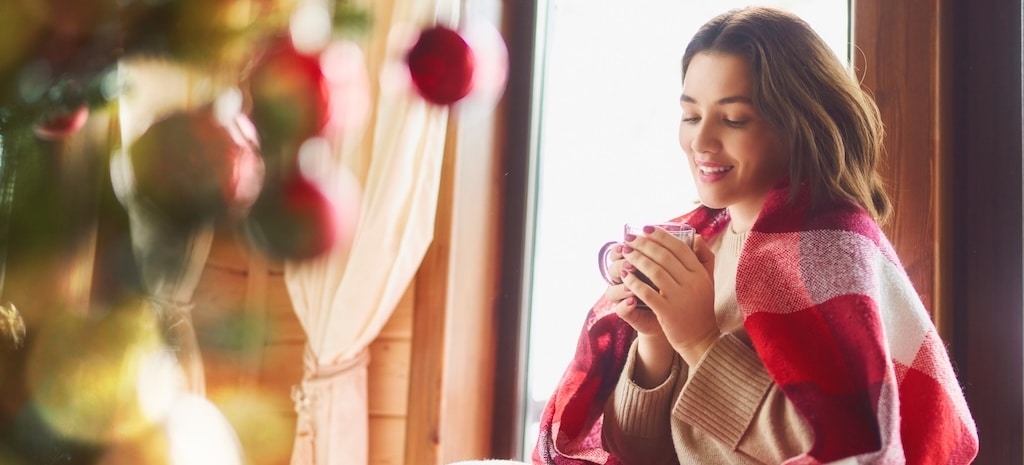 Girl enjoying warm beverage. Christmas time.