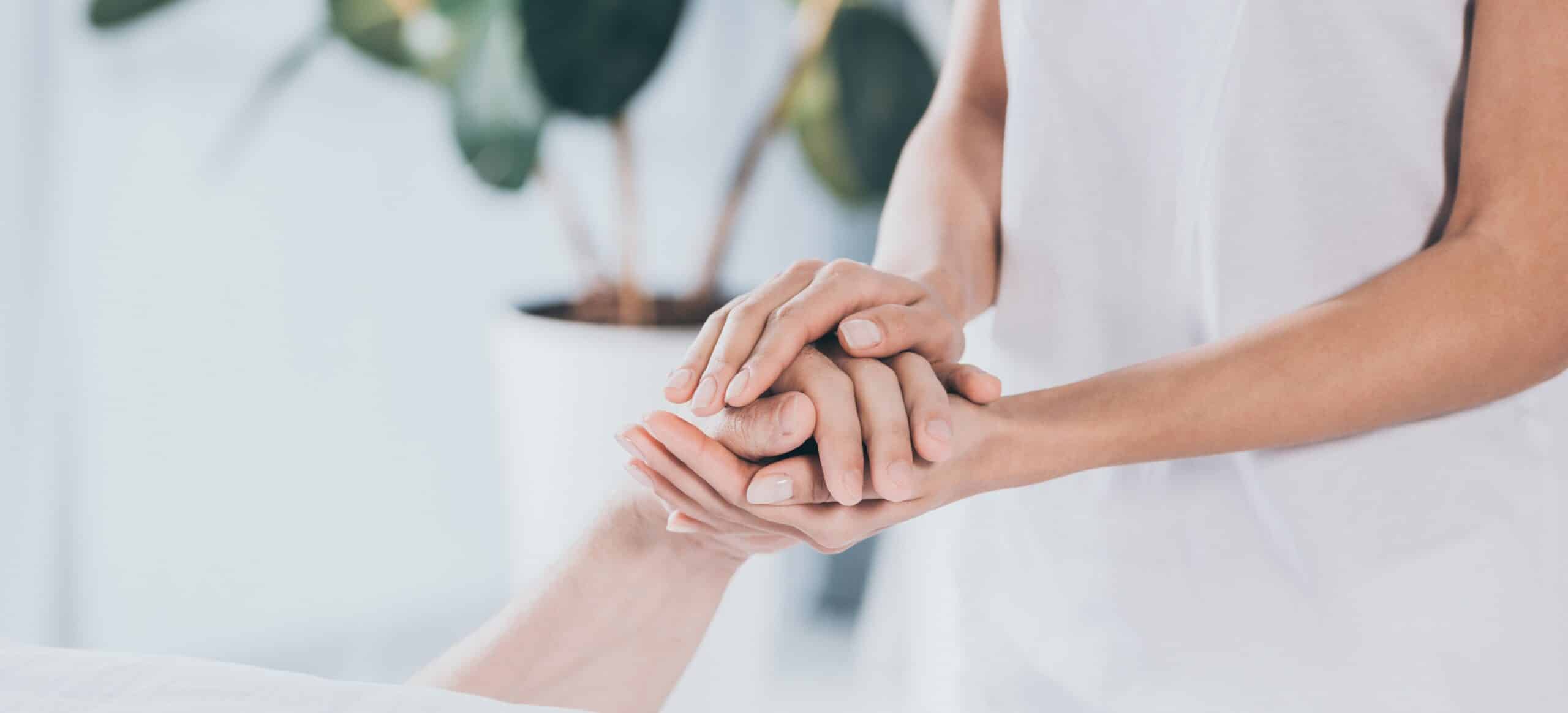 cropped shot of staff member holding hand of patient