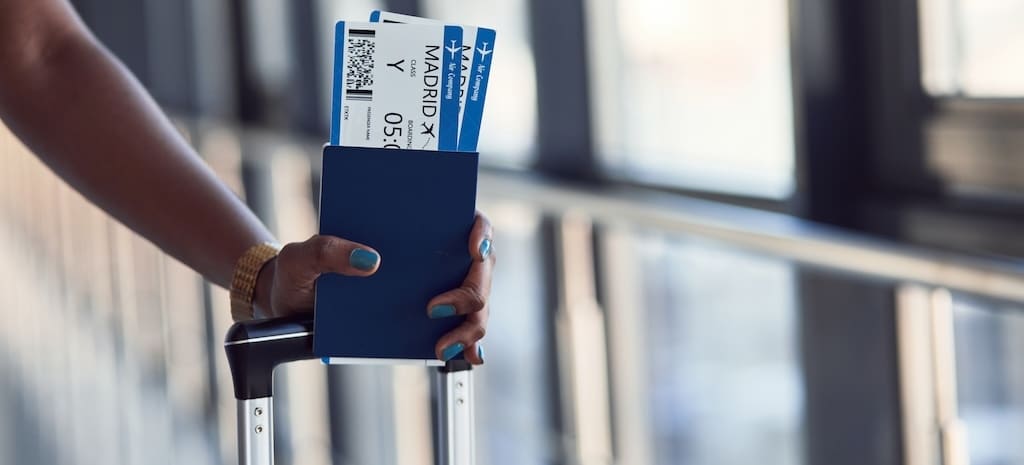 Female passanger in casual clothes is in airport with tickets.