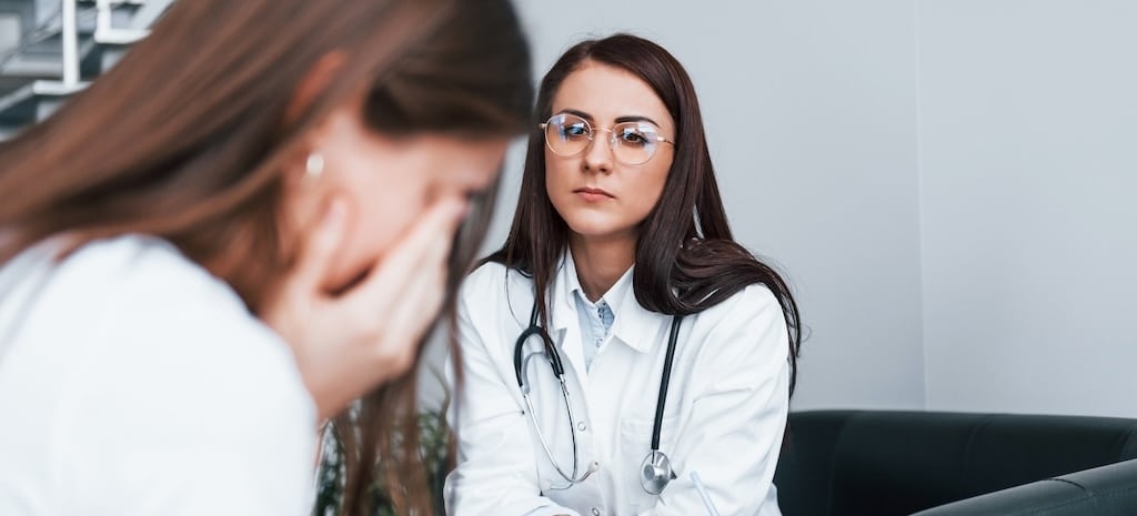 Young woman meeting with female clinician regarding alcohol use.