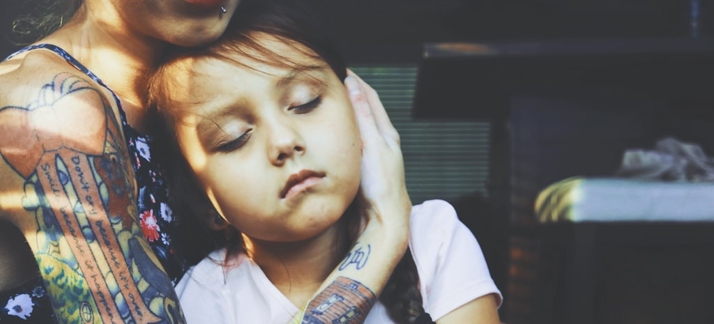 Woman holding her sleeping daughter.