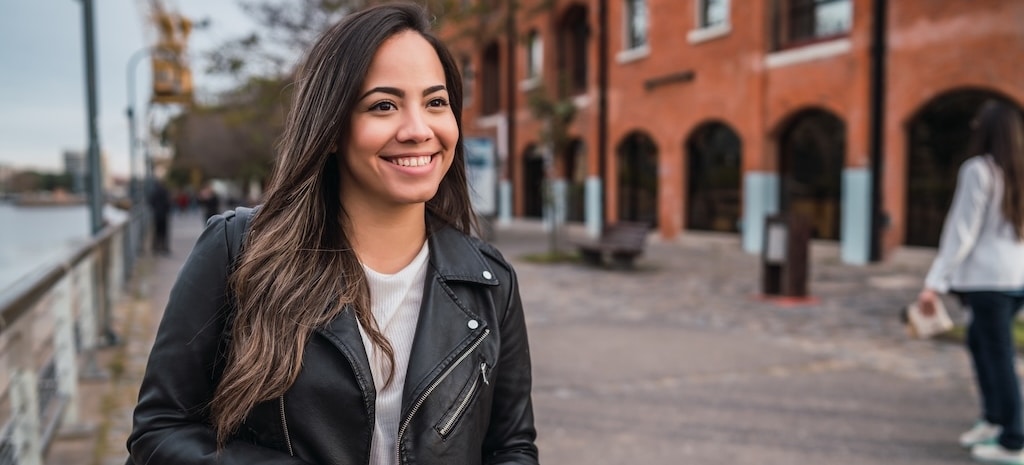 Portrait of young woman holding a cup of coffee outdoors. Urban concept.