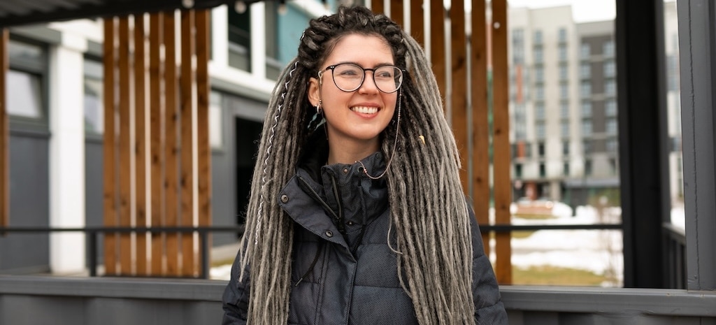 Young person in puffer coat, smiling in the street, urban concept, smiling in hopeful stance, addiction recovery