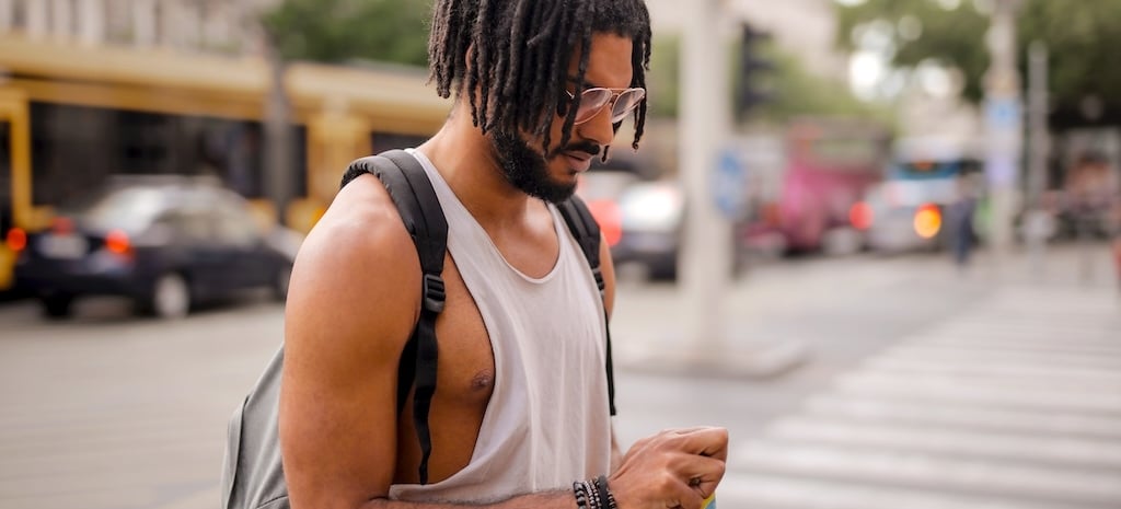 Man with dreadlocks opening an energy drink, representing individuals in recovery and differently lifestyles, paths to healing