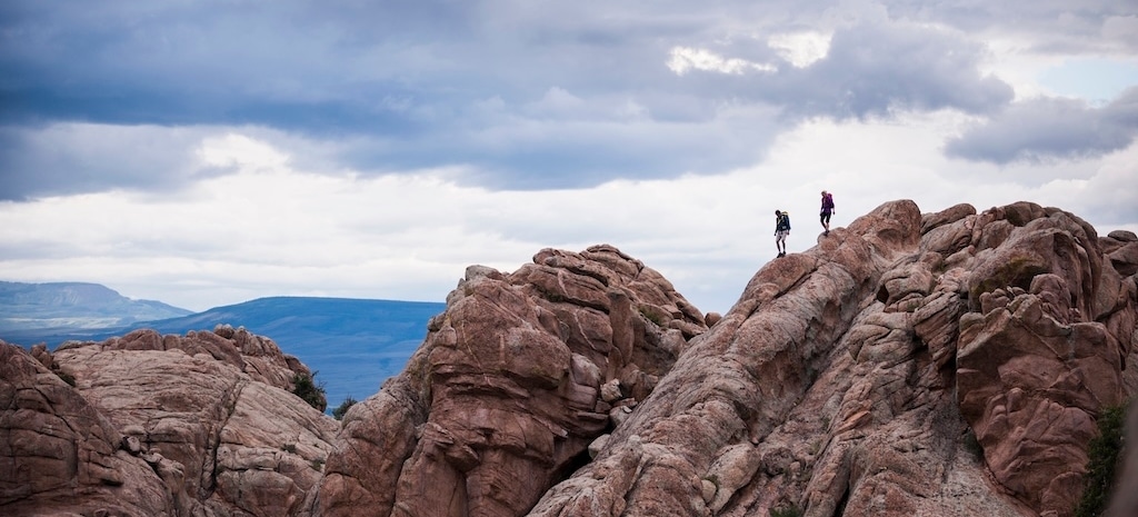 Two people walking on rocks in New Mexico landscape