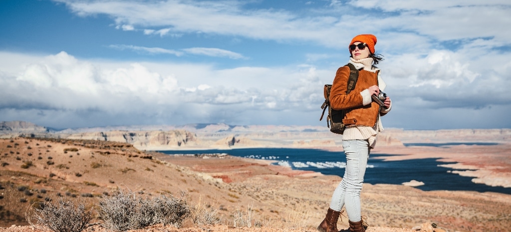 Young person standing in New Mexico landscape with camera, seeking new beginnings, representing healing through addiction treatment