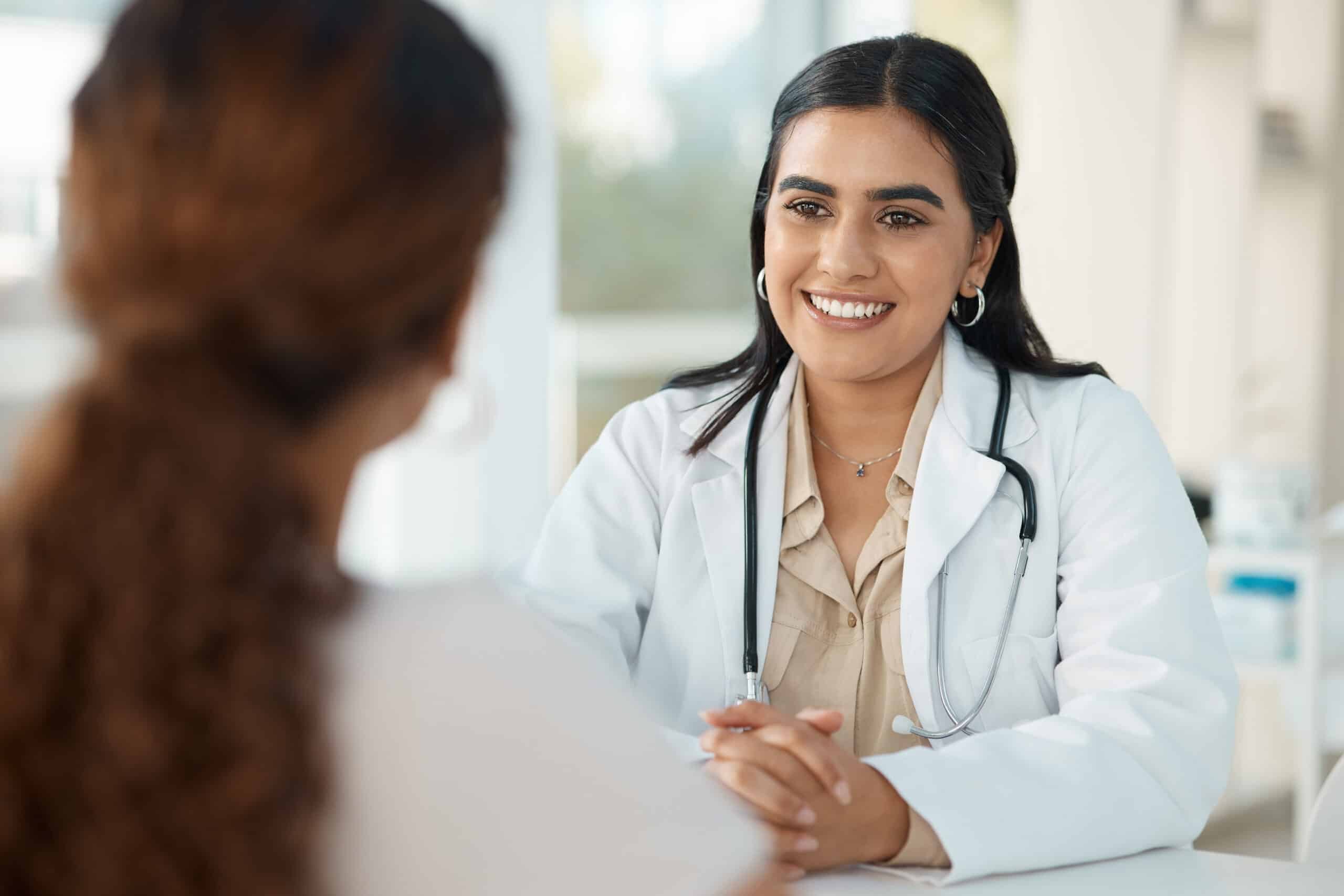 A doctor smiling at a patient while sitting at her desk for the topic suboxone for meth.