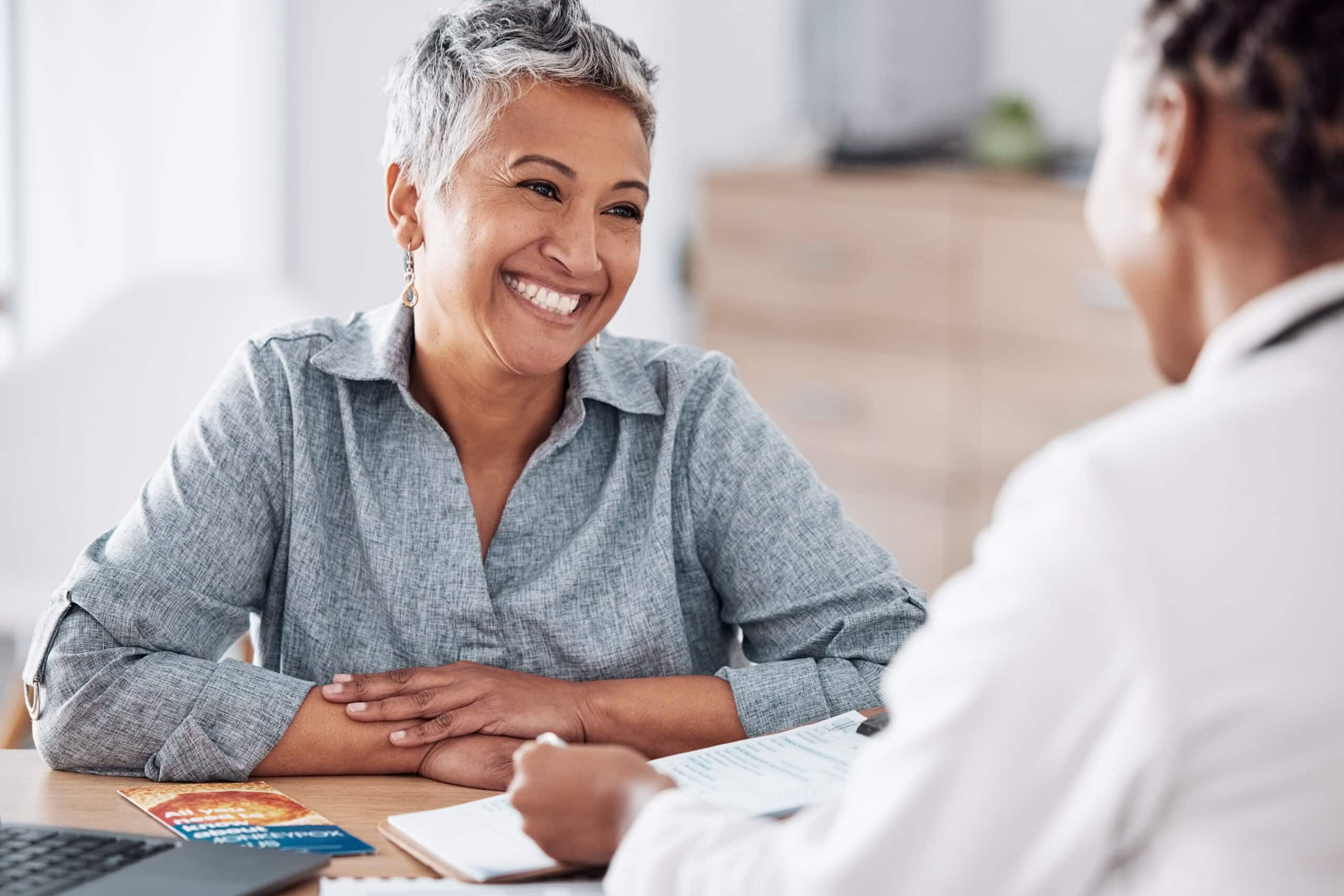 A woman smiling while speaking with a doctor about suboxone for alcohol use disorder.